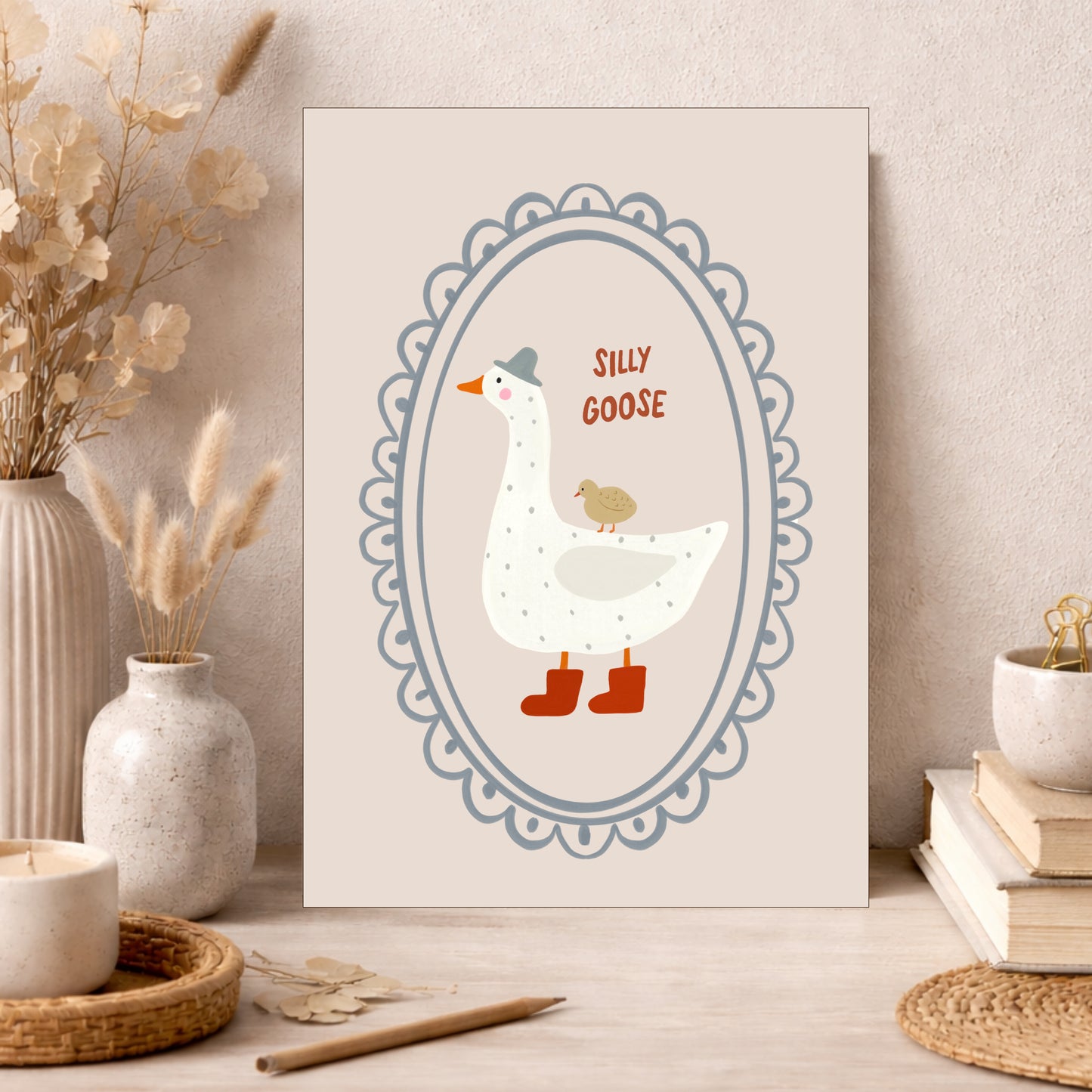 Whimsical white goose wearing a gray hat and red boots with a small bird on its back in a lace oval frame  